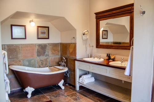 Un baño con dos lavabos y una bañera. en Ikhaya Safari Lodge, en Ciudad del Cabo