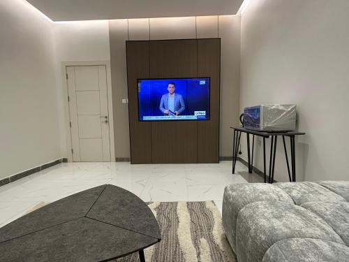 a living room with a flat screen tv on a wall at جناح عائلي غرفة وصول ذاتي in Al Hofuf