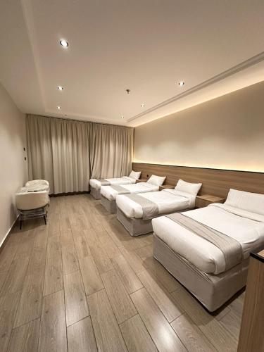 um quarto com uma fila de camas em فندق رواف الفيصلية em An Naqāʼ