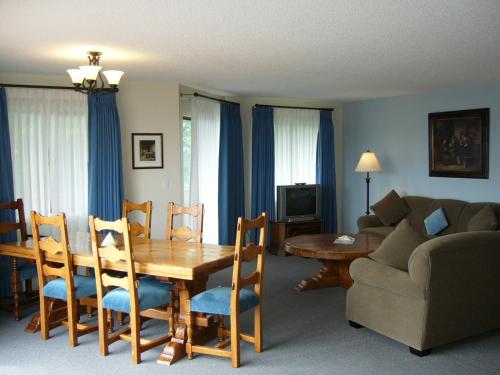 a living room with a wooden table and a couch at Heron's Landing Hotel in Campbell River
