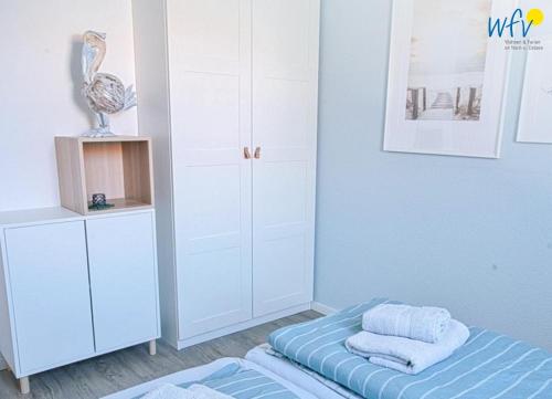 Postel nebo postele na pokoji v ubytování Ferienhäuser Jadehörn Ferienwohnungen Sandfloh Sonnenstern