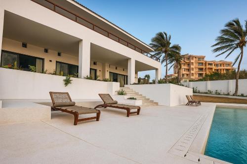 un patio con 2 sedie e una piscina di Casa Del Mar Villa by YourHost 5B – Nyali Mombasa a Mombasa