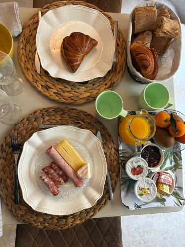 uma mesa coberta com pratos de comida e pão em Chambre Deluxe - vue jardin - située dans le triangle d'or du Luberon em Ménerbes