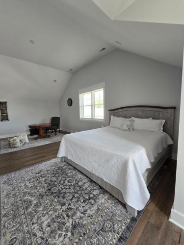 a white bedroom with a large bed and a rug at Luxurious Eastern Shore Getaway in Milton