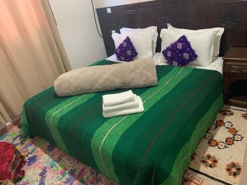 a green bed with two towels on top of it at The Imlil escape Retreat in Tamatert