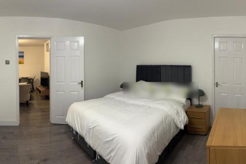 West BoldonにあるBungalow - Sleeps 2 - Parking - Gardenの大きな白いベッドと机のある寝室