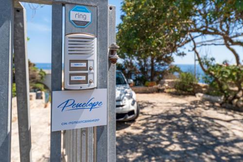 a payphone sign in front of a car at Villa fronte mare nel Salento in Castro di Lecce