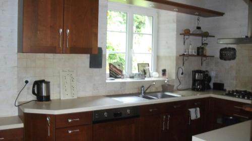 eine Küche mit Spüle und Fenster in der Unterkunft Gîte Les Hervelines in Le Val Hervelin