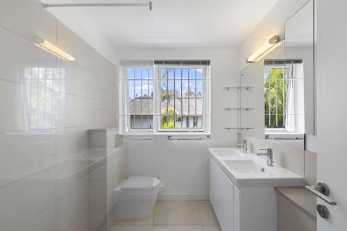 a white bathroom with a sink and a toilet at Croix Du Sud by Host Agents in Palmar