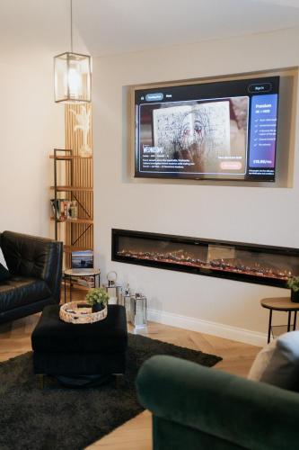 a living room with a flat screen tv above a fireplace at Marine Cottage 2 - With Private Hot Tub in Newbiggin-by-the-Sea