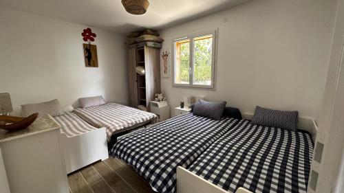 ein Schlafzimmer mit zwei Betten und einem Fenster in der Unterkunft Villa Mimosa - 5 voyageurs in Le Moutchic