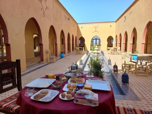 a table with food on it in a building at Hotel Berber Palace Merzouga in Hassilabied