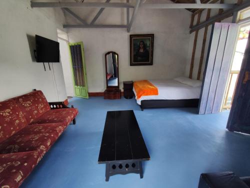 a living room with a couch and a bed at Hostal Casa Pijao in Pijao