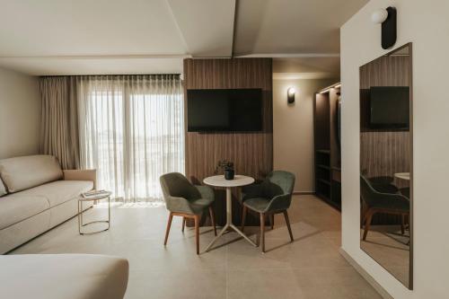 a living room with a couch and a table and chairs at Regional Hotel by NEU Collective in Il-Gżira