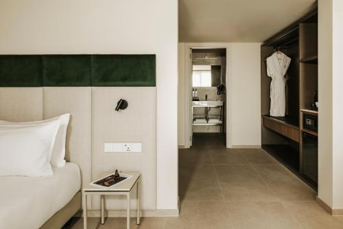 a bedroom with a bed and a dressing room at Regional Hotel by NEU Collective in Il-Gżira