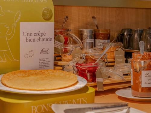 una mesa con un plato de comida en un mostrador en Mercure Lyon Est Villefontaine, en Villefontaine