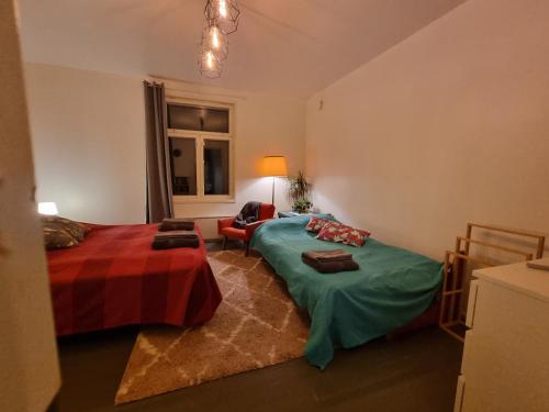 Un dormitorio con dos camas y un sofá y una silla. en Pispalan Helmi - Koti Näköalalla, en Tampere