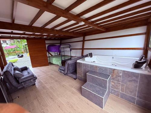 a large bathroom with a tub and chairs in a room at Finca de Descanso El Ocaso in Sevilla
