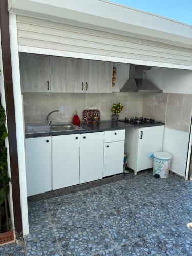 a kitchen with white cabinets and a sink at Gönül Evim in Bogazici