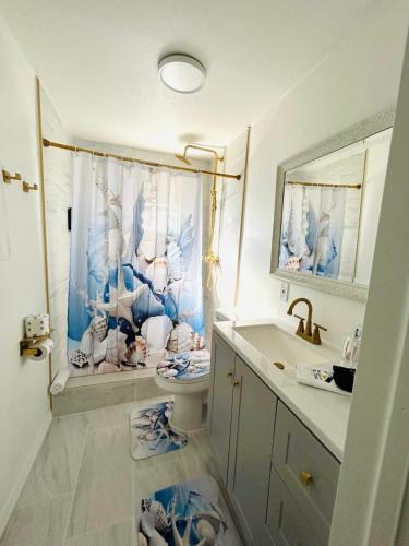 a bathroom with a shower curtain and a toilet and a sink at Playa Esmeralda Cottage! Add Golf Cart!! in Bradenton Beach