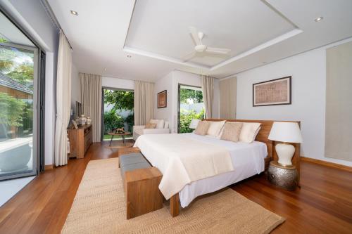 une chambre avec un lit et un salon dans l'établissement Anchan Tropicana 4 bedroom near Beach, à Phuket