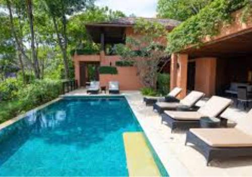 a swimming pool with couches and chairs next to a house at GoldCrest Mall Luxury Apartments with Balcony In DHA Lahore in Lahore