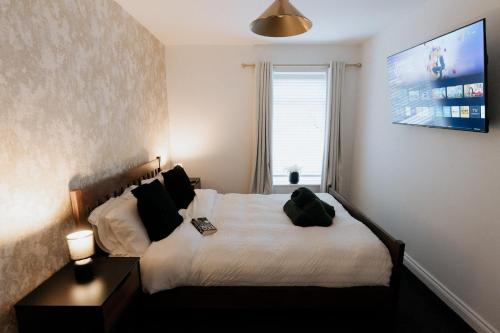 a bedroom with a bed and a tv on the wall at Marine Cottage 2 - With Private Hot Tub in Newbiggin-by-the-Sea