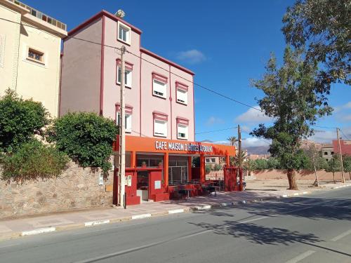 a red building on the corner of a street at Maison d'hôtes afoulki tafraout in Tafraout