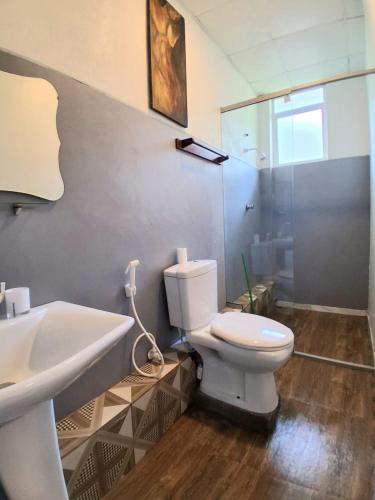 a bathroom with a white toilet and a sink at Mbeach Nest in Panadura