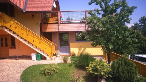 a house with yellow stairs and a balcony at Apartment Beli Zajec in Mozirje