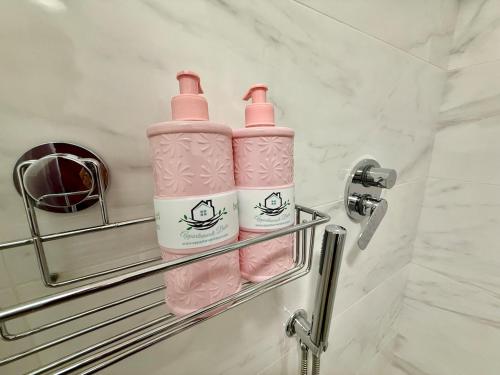 Dos botellas rosas en un toallero en un baño en Suite dei Principi 2, aeroporto e parcheggio gratuito, en Bari