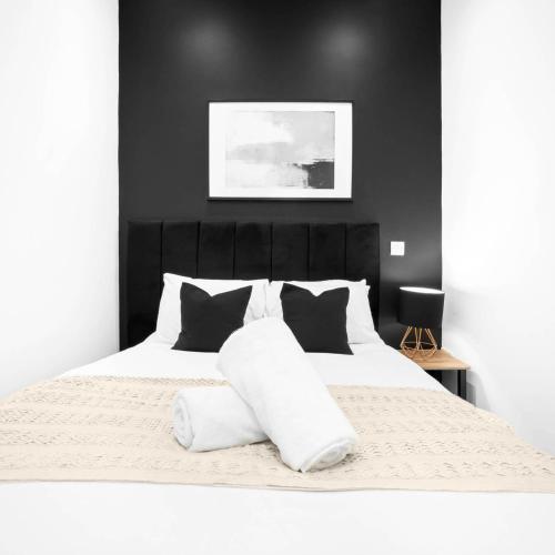 a bedroom with a white bed with black walls at Cozy Apartment - Netflix - On Street Parking - Rowley Regis 49G in Halesowen