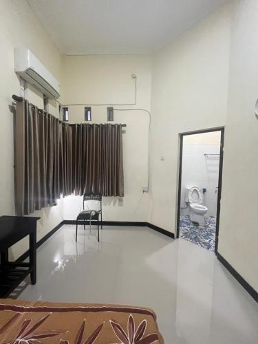a living room with a toilet and a mirror at Rama Shinta Keragilan Residence in Timuran