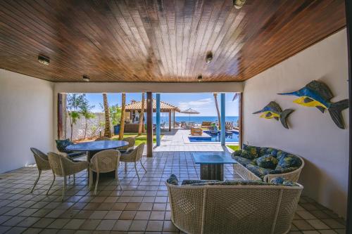 a patio with tables and chairs and a view of the ocean at Mar a Vista Charme by Concavus in Porto De Galinhas
