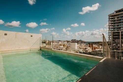 a swimming pool on the roof of a building at Regional Hotel by NEU Collective in Il-Gżira