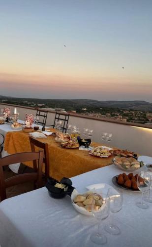 a table with plates of food and wine glasses at Attiko B&B in Palazzolo Acreide