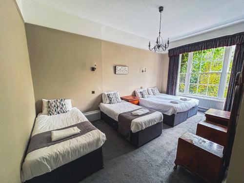 a hotel room with two beds and a window at Garden House Stamford in Stamford