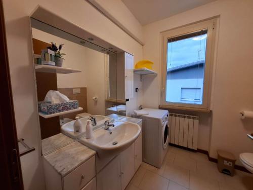 une salle de bain avec un lavabo et une machine à laver dans l'établissement Casa Vacanza Ninfea, à Paratico