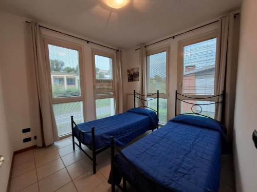 deux lits dans une chambre avec deux fenêtres dans l'établissement Casa Vacanza Ninfea, à Paratico