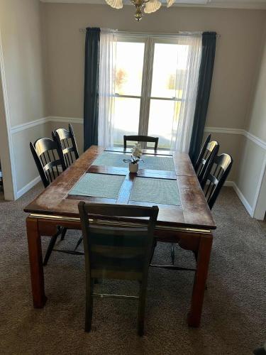 a dining room table with chairs and a large window at The Parkside Townhome in Columbus