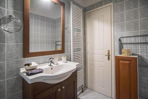 a bathroom with a sink and a mirror at Cozy Attic Suite - Elia Apartments Chrisso in Delfoi