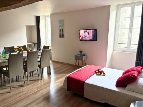 a bedroom with a bed and a dining room at Les Glaneuses Gîte Le Grand 8 centre-bourg 3 min du Puy duFou in Les Épesses