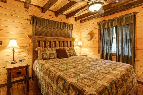 ein Schlafzimmer mit einem Bett in einer Blockhütte in der Unterkunft Cozy Couples Getaway with Hot Tub Fox Ridge Cabin in Whittier