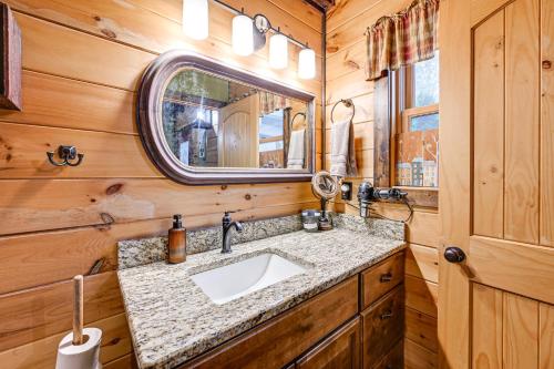 ein Badezimmer mit Waschbecken und Spiegel in der Unterkunft Cozy Couples Getaway with Hot Tub Fox Ridge Cabin in Whittier