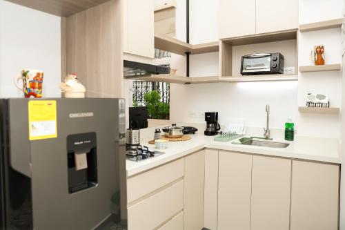 una cucina con mobili bianchi e un frigorifero di Casa del Viento 101 a Cali