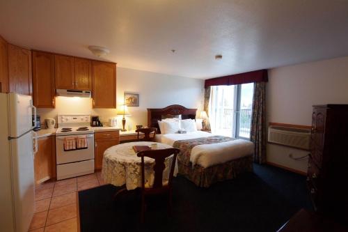 a hotel room with two beds and a kitchen at Executive House Suites Hotel & Conference Centre in High Level