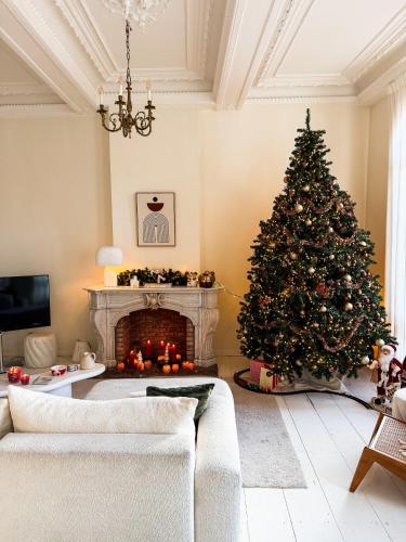 een kerstboom in een woonkamer met een open haard bij Mansion RL with Unique Decoration in Antwerpen