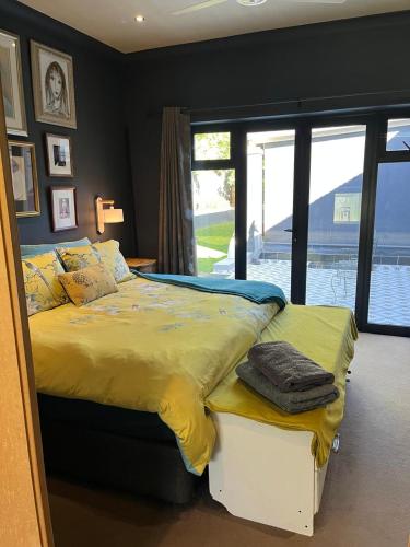 a bedroom with a large bed with a yellow comforter at Franschhoek Guest Suite in Franschhoek