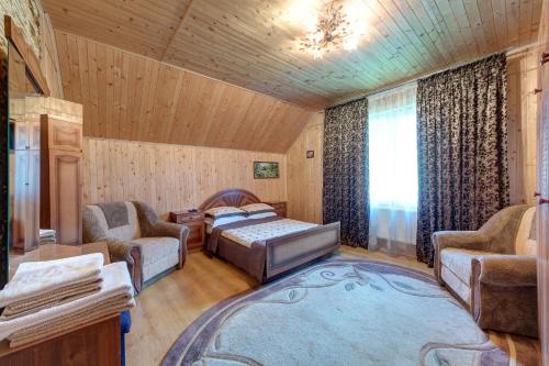 a living room with a bed and two chairs at Guest House Velet in Bukovel