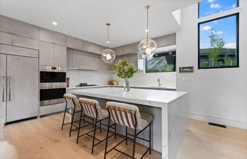 eine Küche mit einer großen weißen Insel mit Barhockern in der Unterkunft Modern Jackson Getaway Near Town Square in Jackson